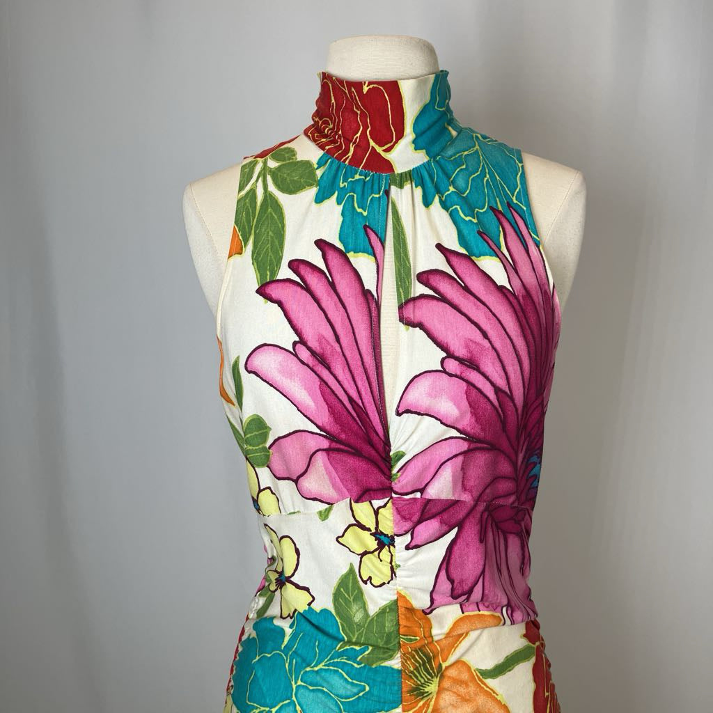 Colorful floral dress on a mannequin against a plain background