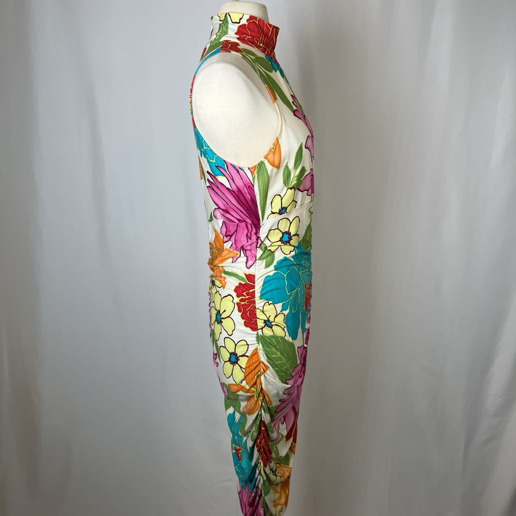 Colorful floral dress on a mannequin against a plain background