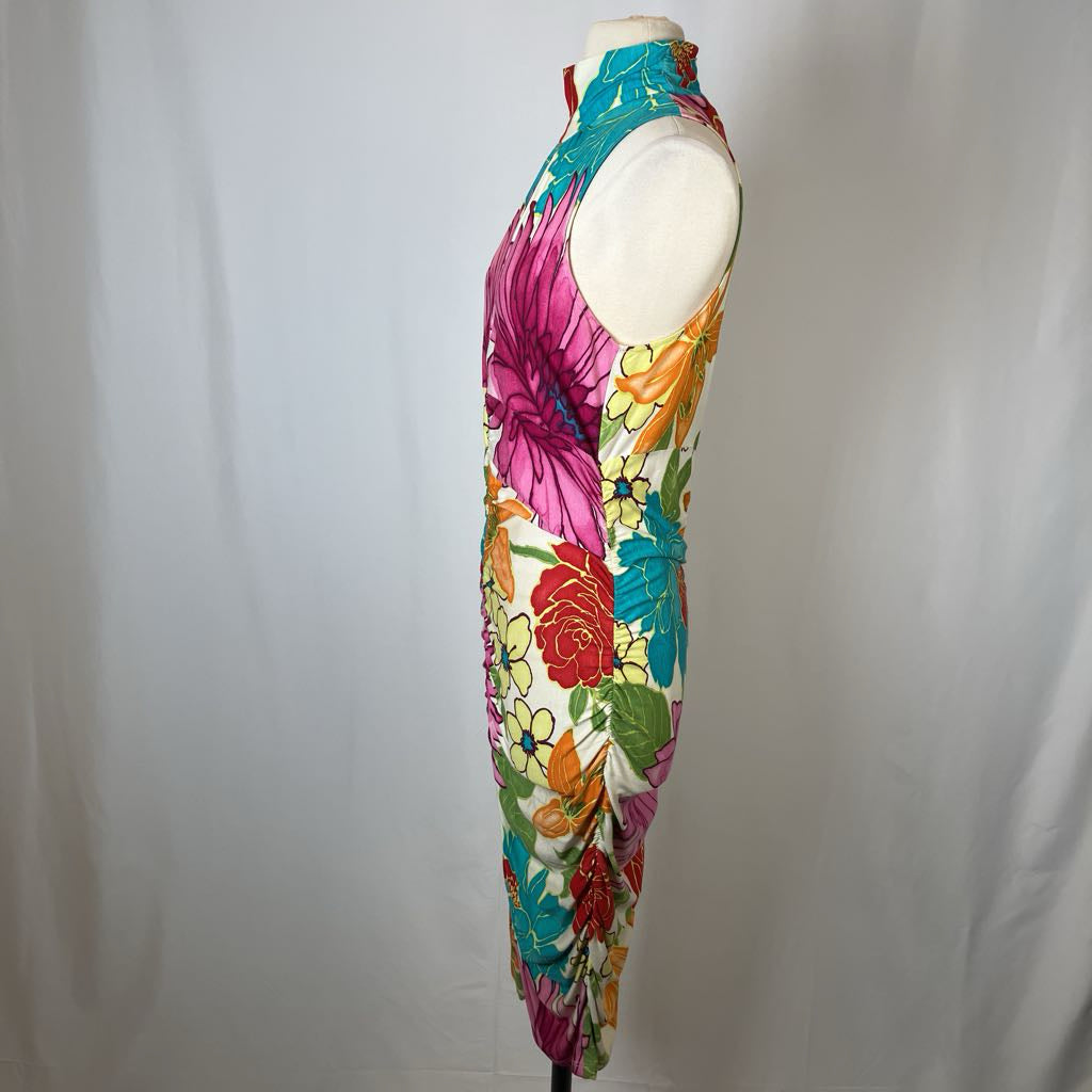 Colorful floral dress on a mannequin against a plain background