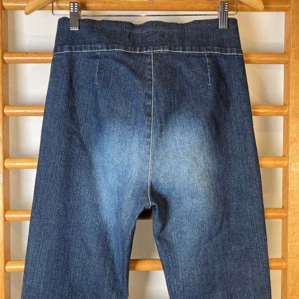 Blue jeans hanging on a wooden rack.