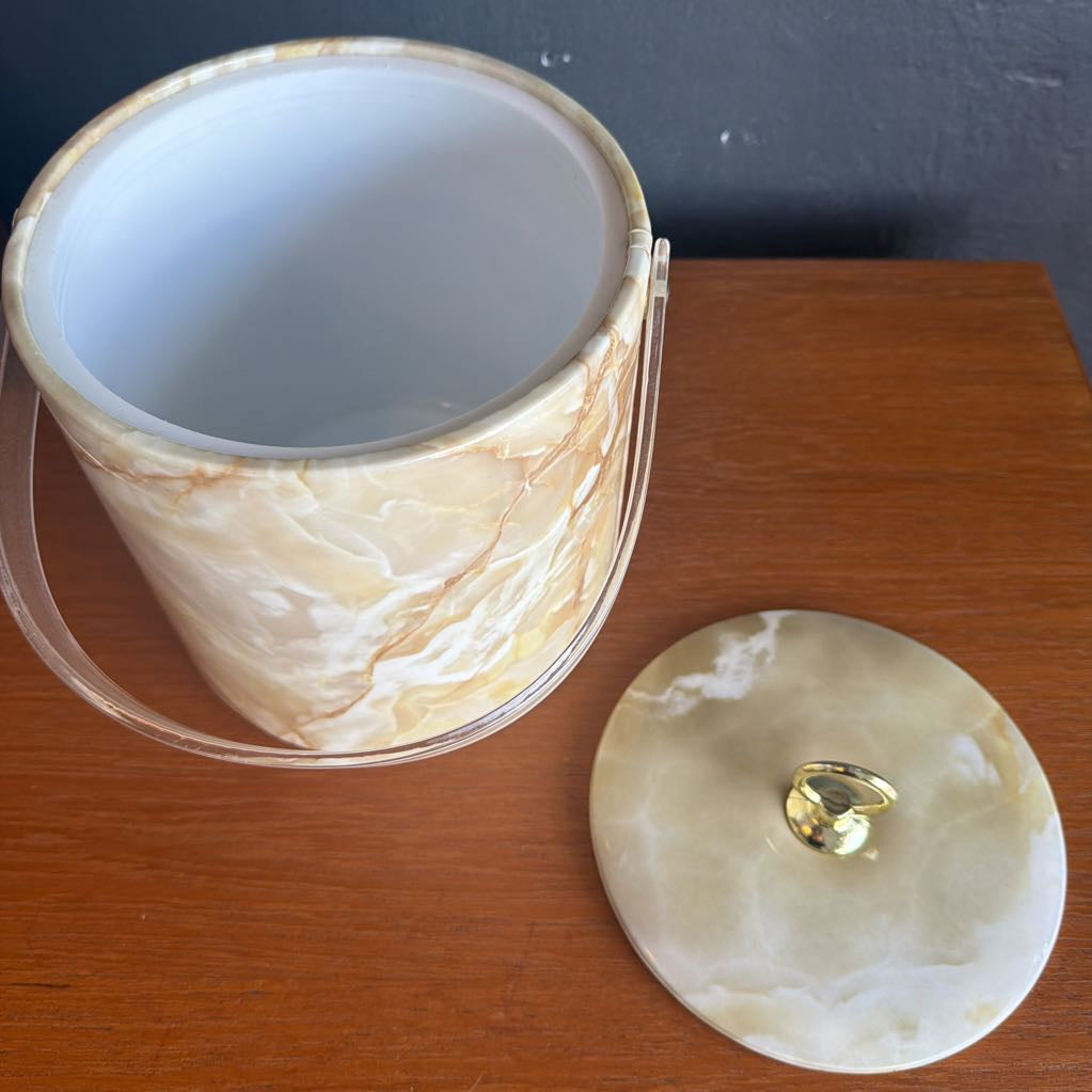 Marble-patterned container with a lid on a wooden surface