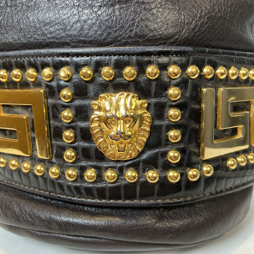 Black leather belt with gold lion head emblem and studded details