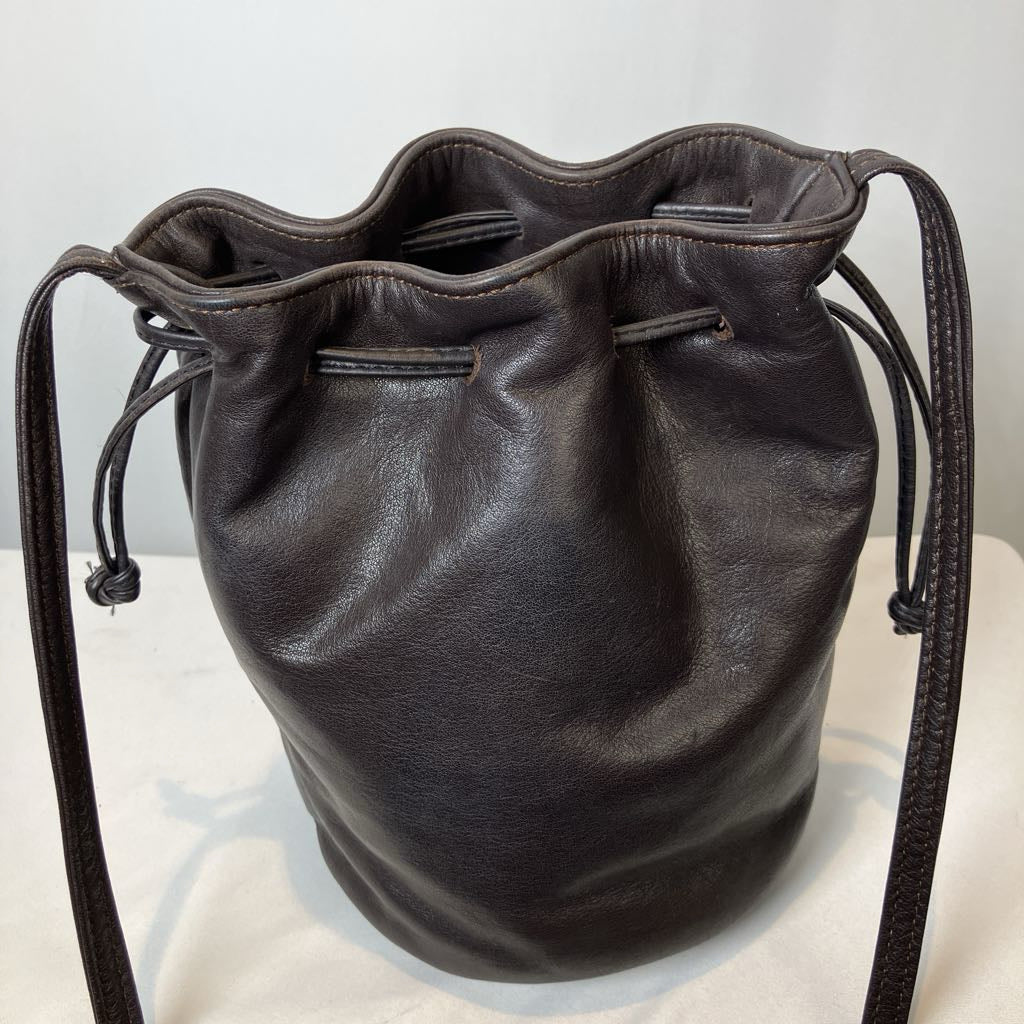 Black leather drawstring bag on a light gray background
