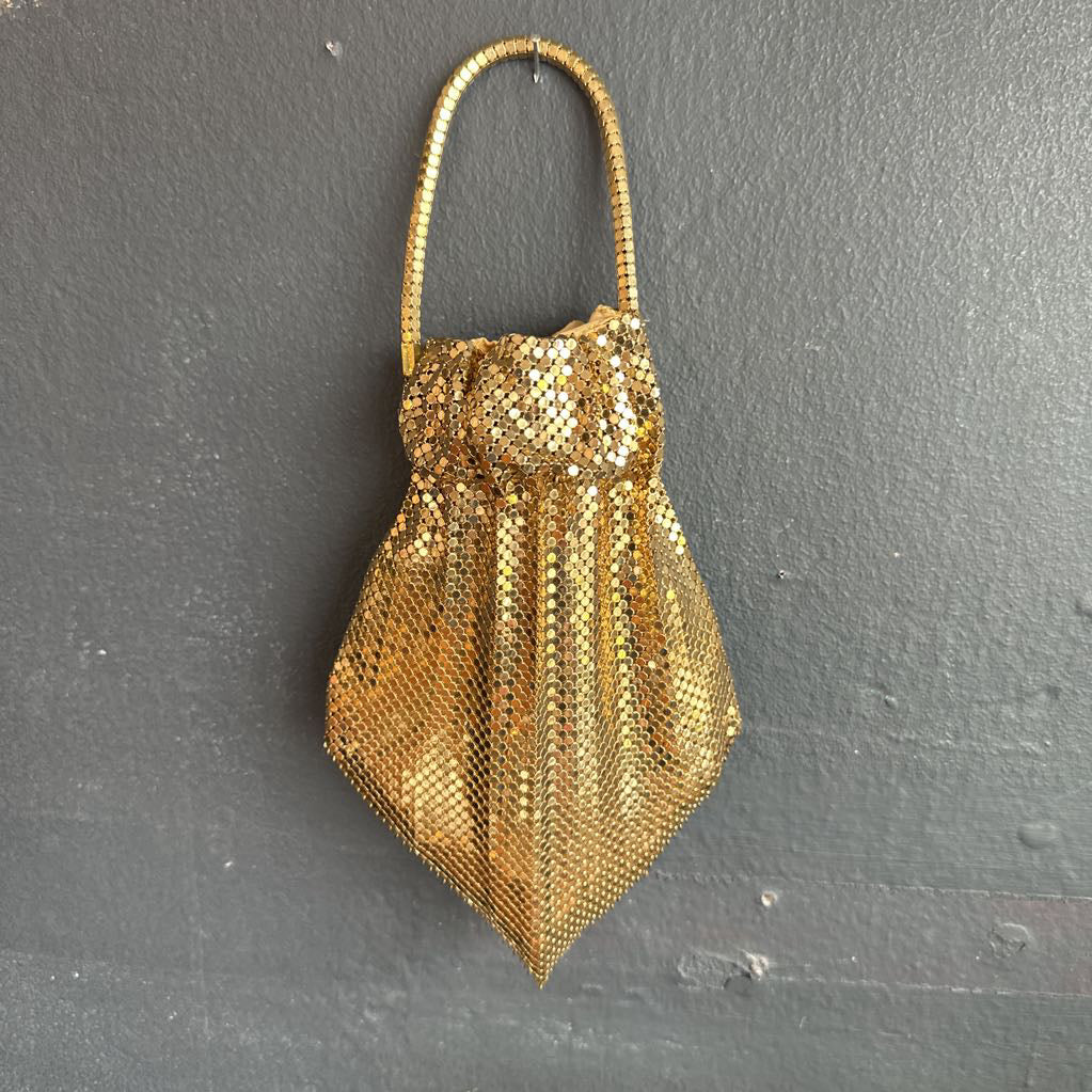 Gold mesh handbag on a dark gray background