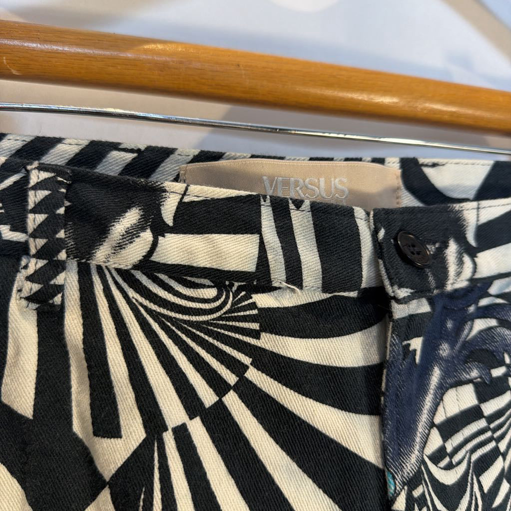 Close-up of a black and white patterned garment with 'Versus' branding on a hanger.