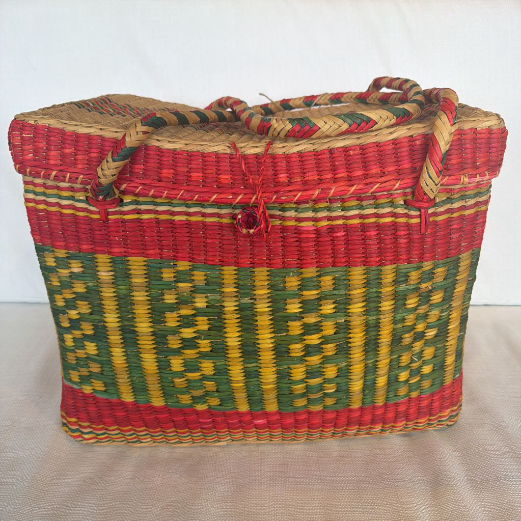 Woven basket with red, green, and yellow pattern on a white background