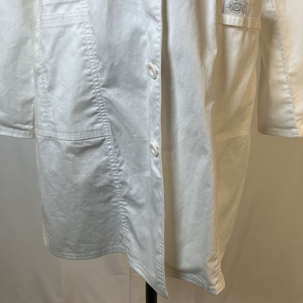 Light blue shirt with a button placket on a hanger against a beige background