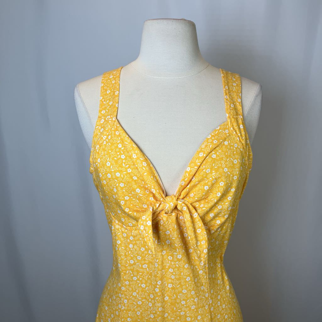 Yellow floral dress on a mannequin against a plain background