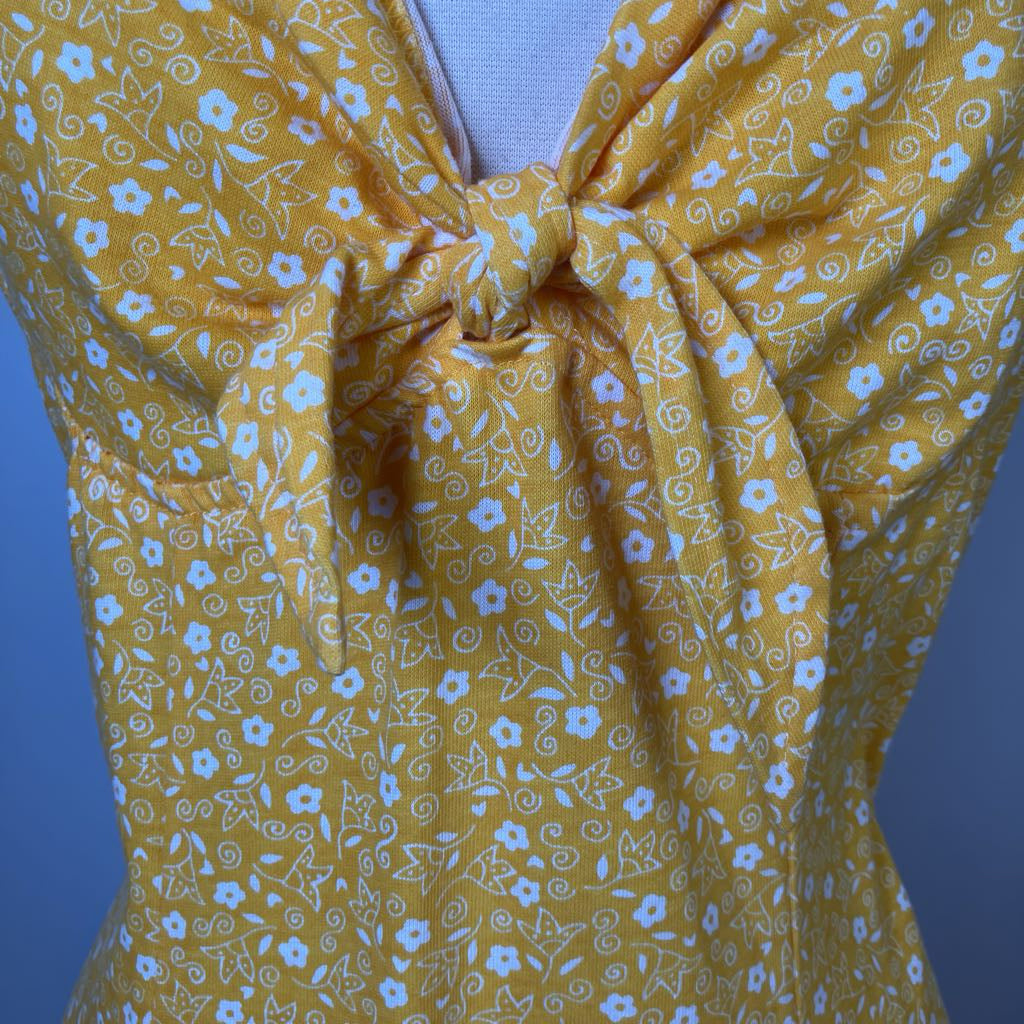 Yellow floral dress with a knot detail on a blue background