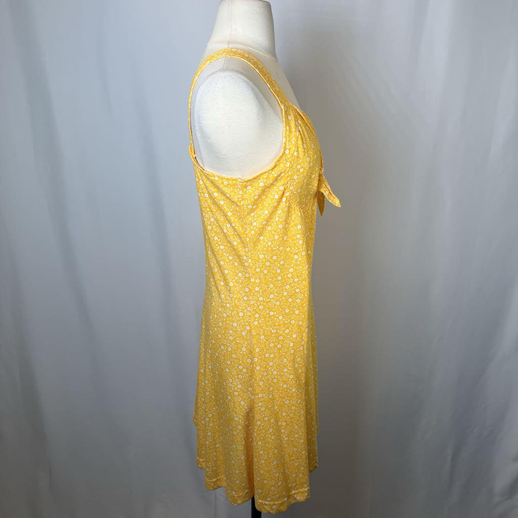 Yellow dress with floral pattern on a mannequin against a plain background