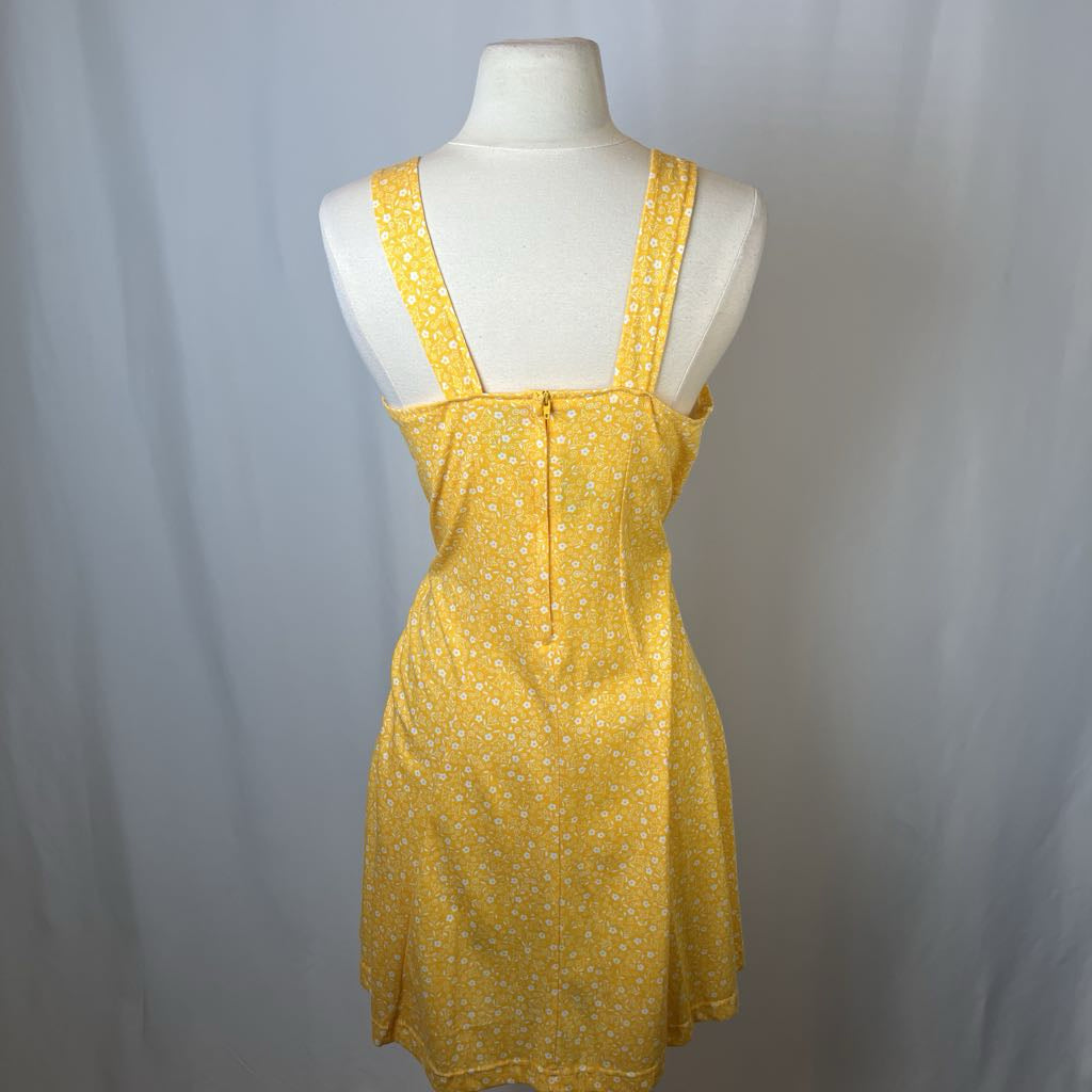 Yellow dress on a mannequin against a plain background