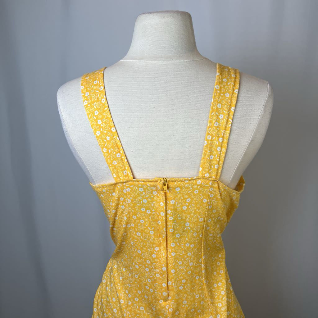 Yellow floral dress on a mannequin against a gray background