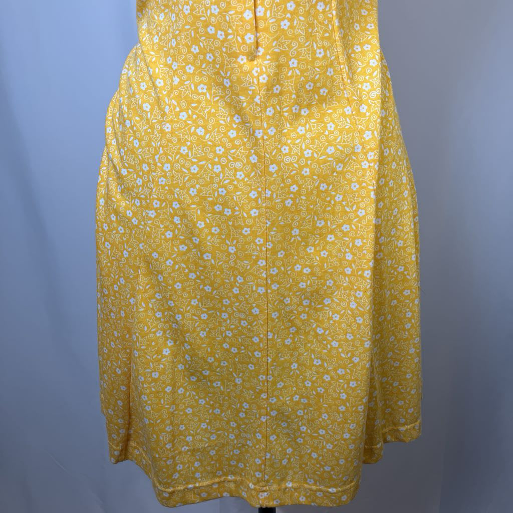 Yellow floral dress on a mannequin against a gray background
