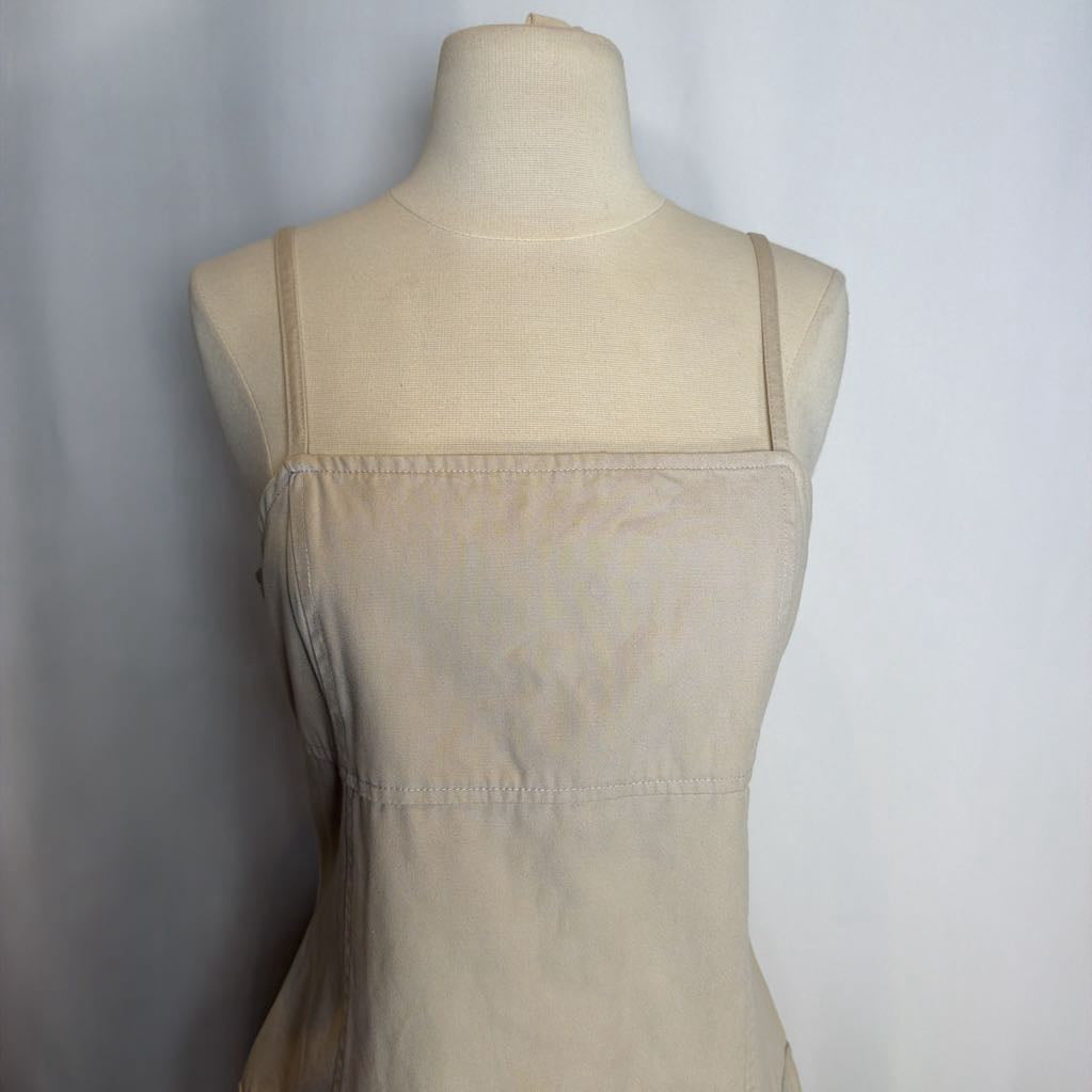 Beige dress on a mannequin against a plain background