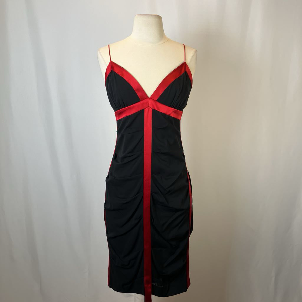 Black dress with red accents on a mannequin against a white background