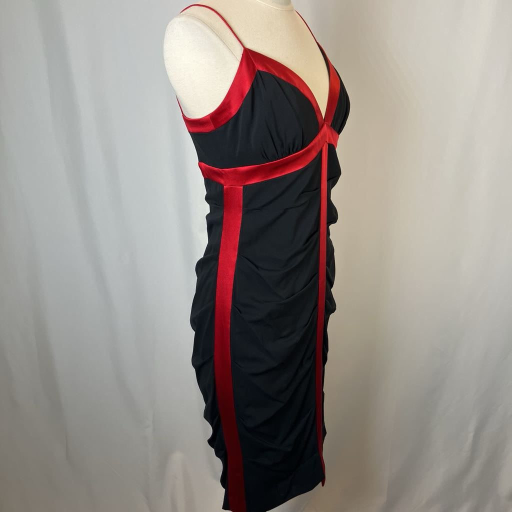 Black dress with red accents on a mannequin against a plain background