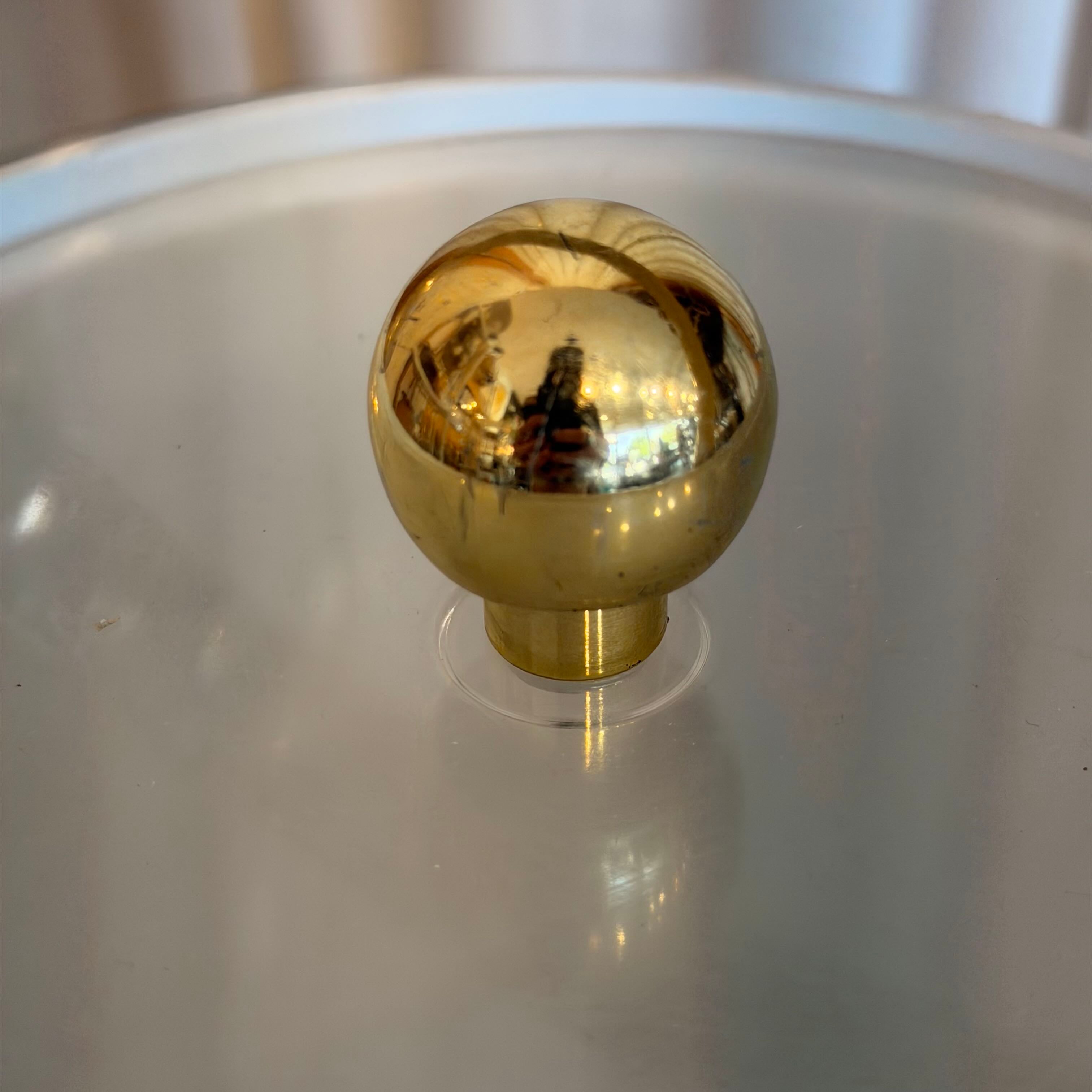 Gold knob on a white surface