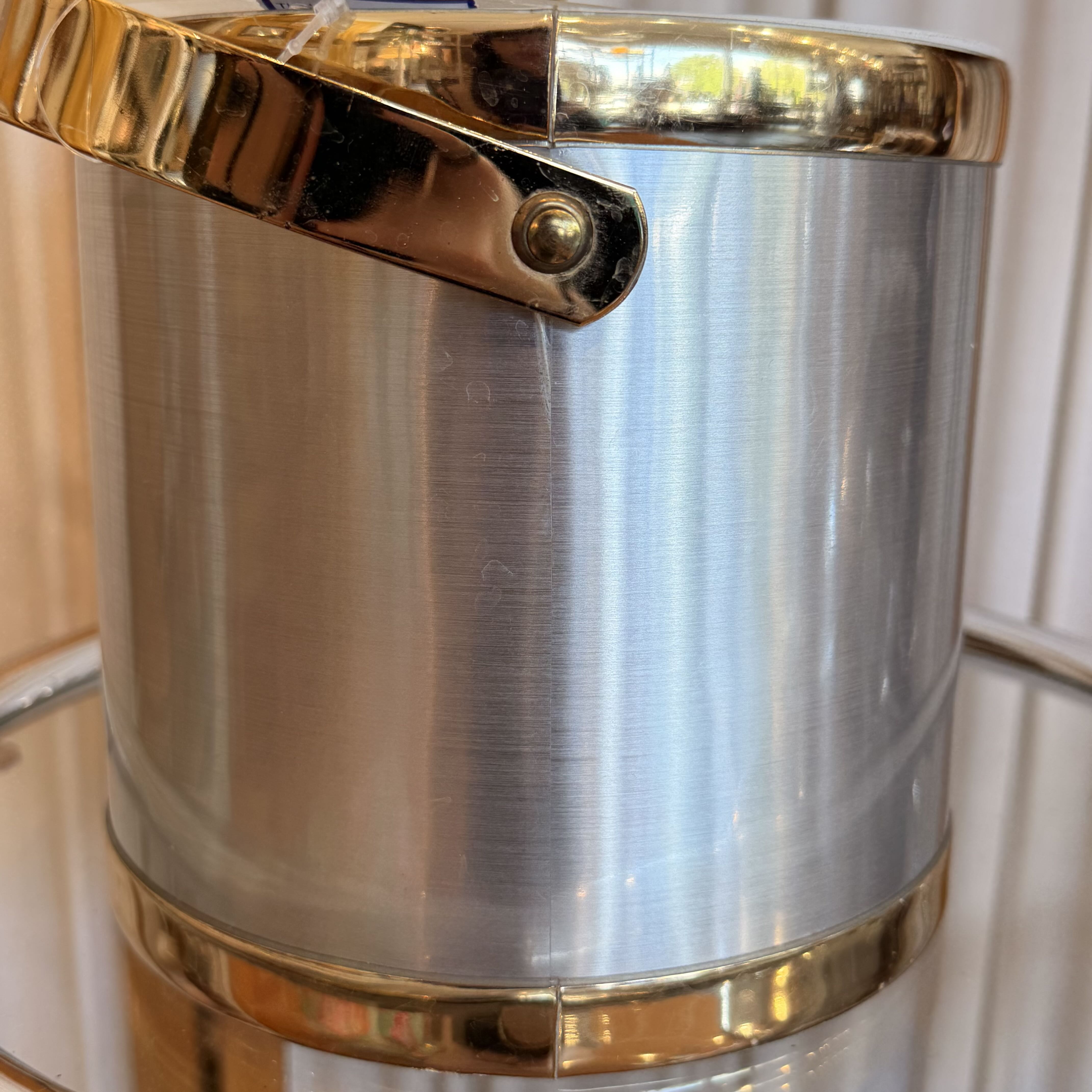 Metallic silver bucket with gold accents on a white background