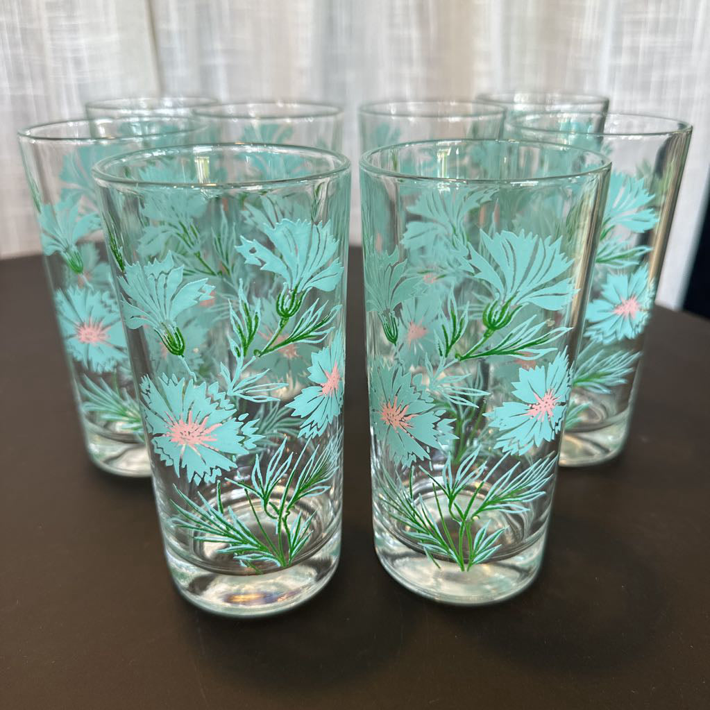 Set of 8 floral-patterned glasses on a dark surface with a light curtain background.