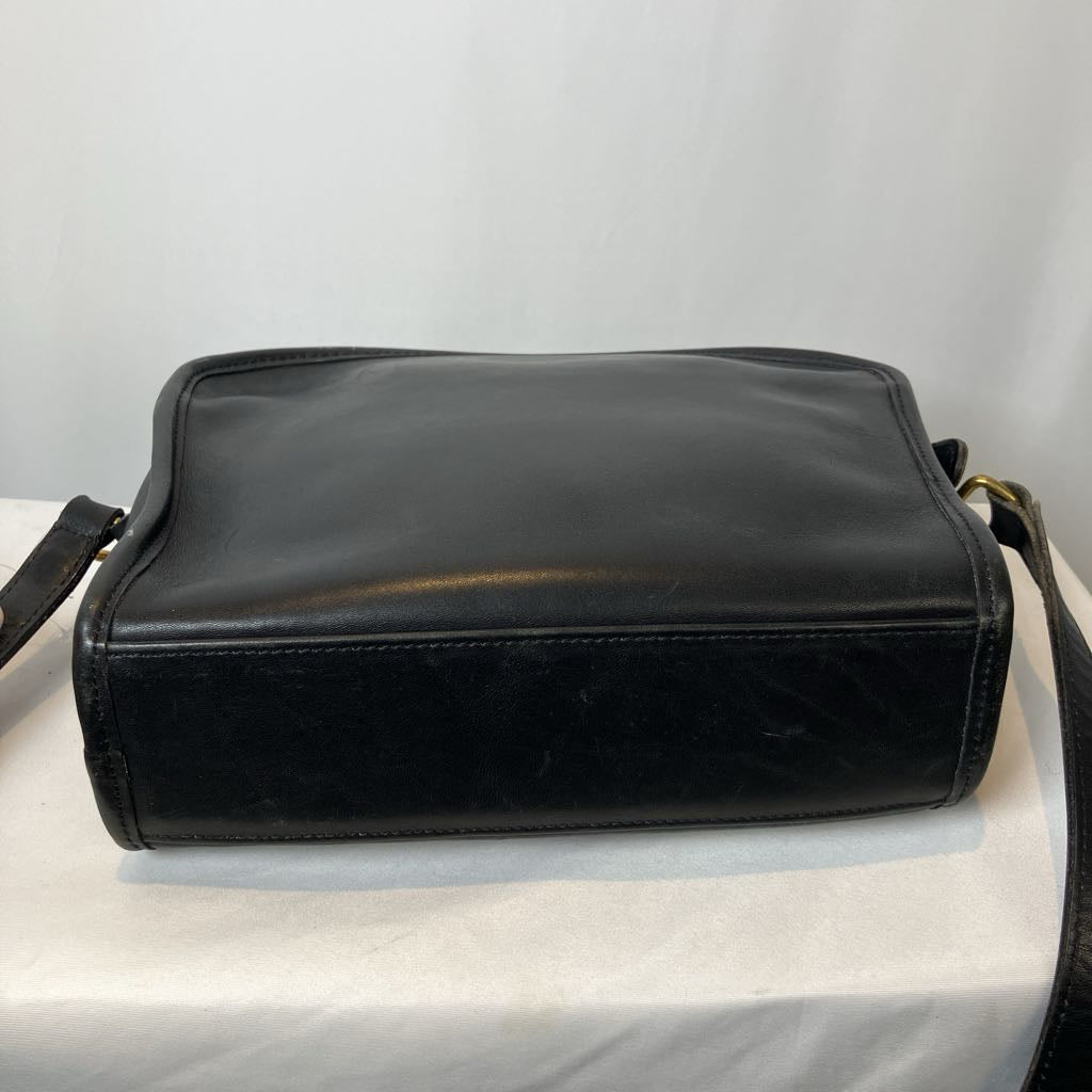 Black leather handbag on a light gray background