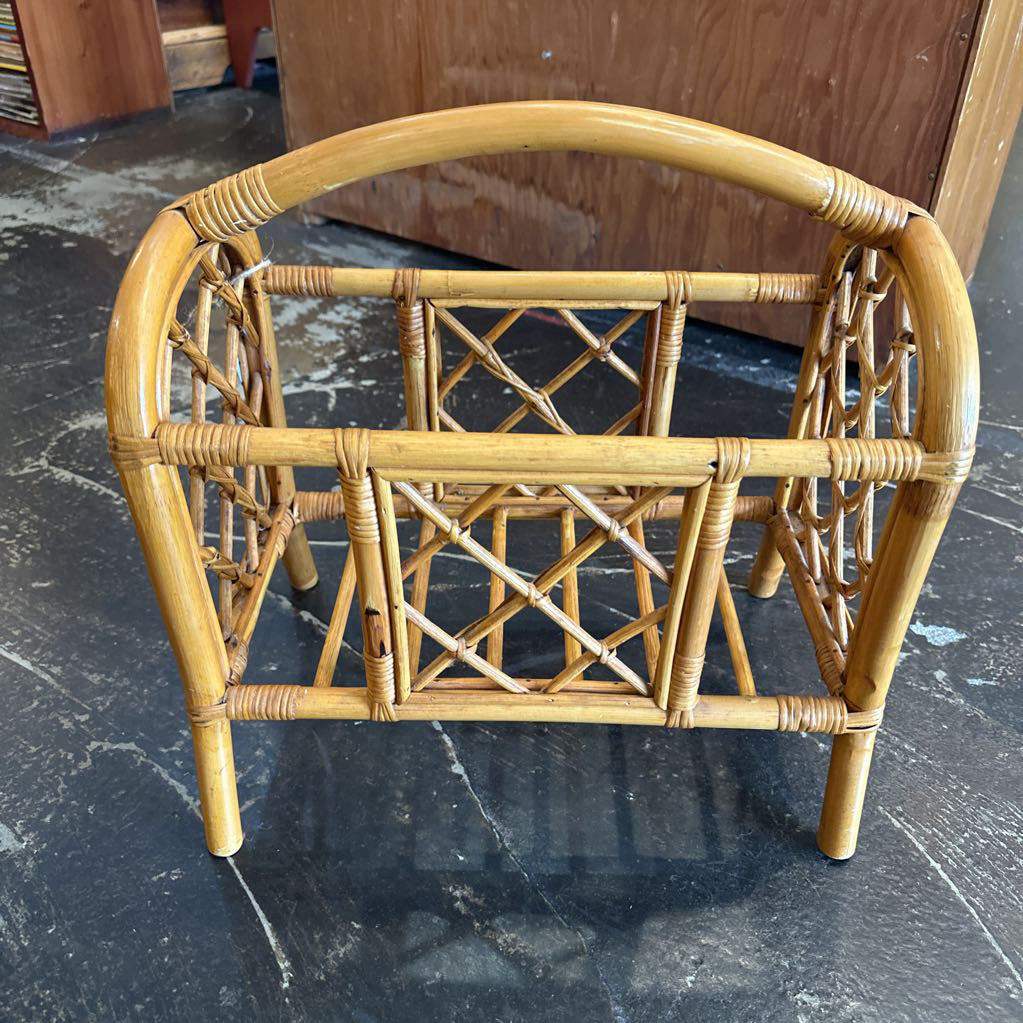 Wicker magazine rack on a dark marble floor
