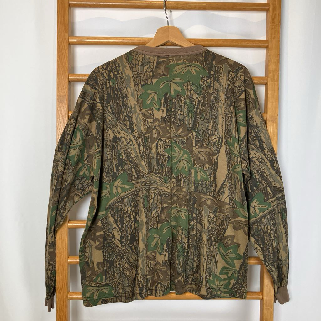 Camouflage-patterned jacket on a wooden hanger against a white wall