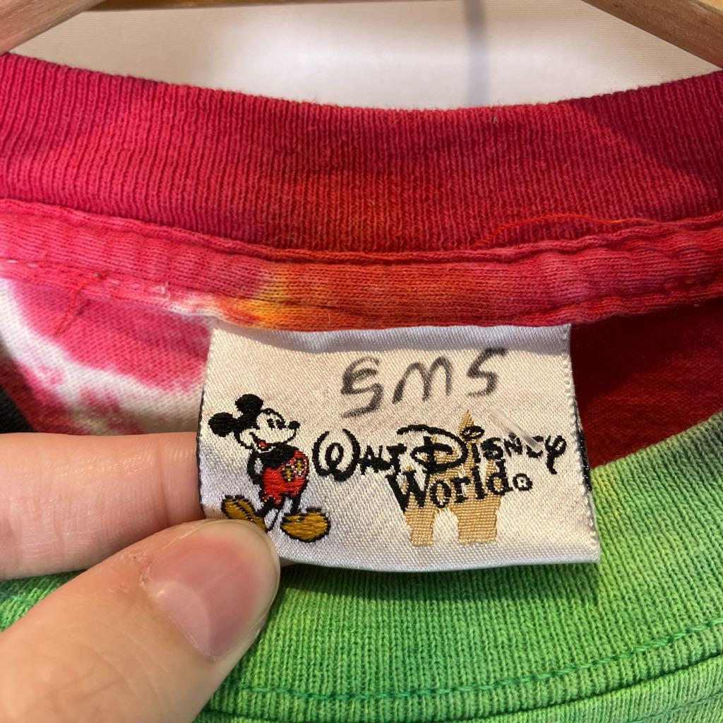 Close-up of a Disney World tag on a garment with a hand holding it.