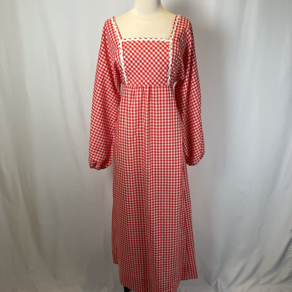 Red and white checkered dress on a mannequin against a plain background