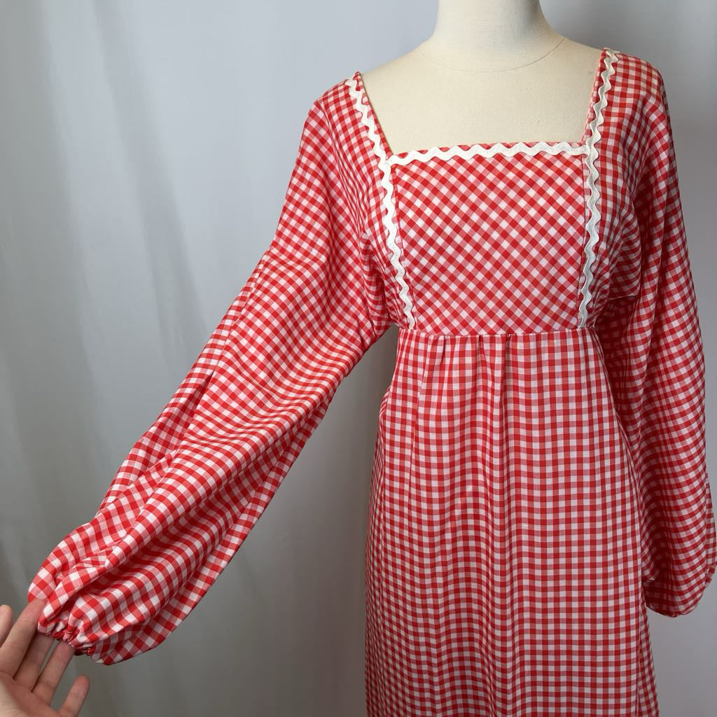 Red and white checkered dress on a mannequin against a gray background