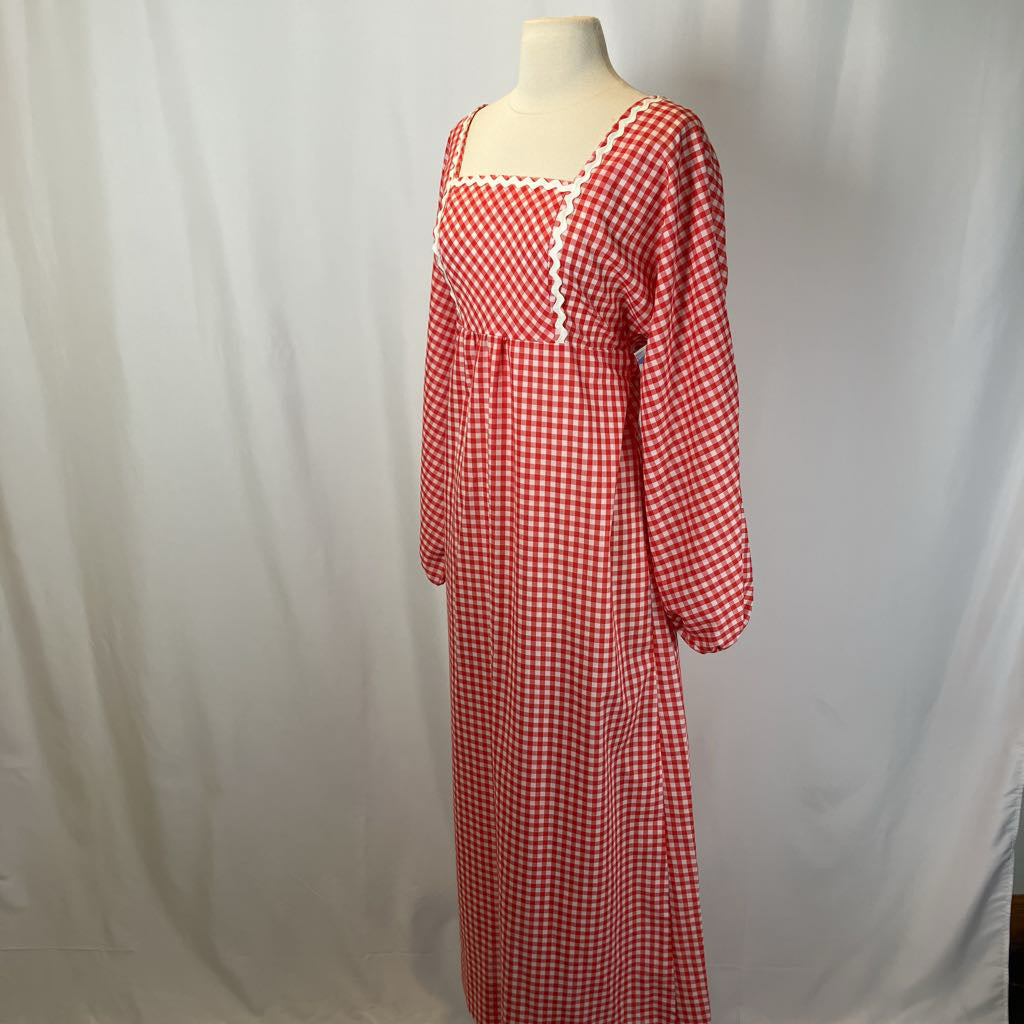 Red and white checkered dress on a mannequin against a plain background
