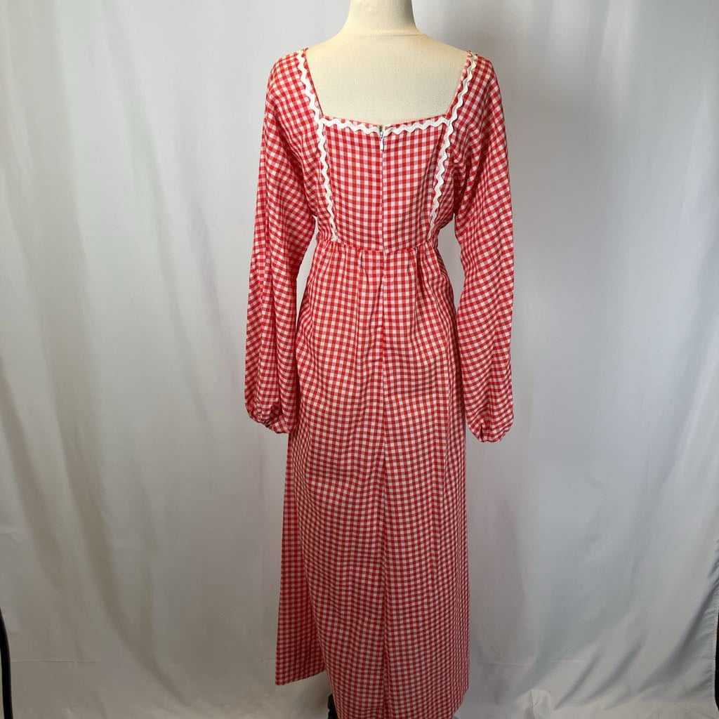 Red and white checkered dress on a mannequin against a plain background