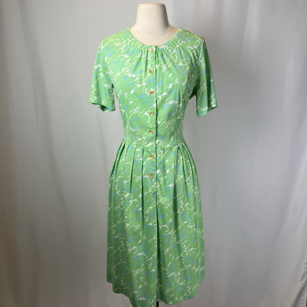 Green floral dress on a mannequin against a plain background