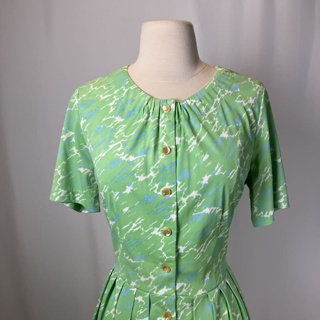 Green patterned dress on a mannequin against a gray background