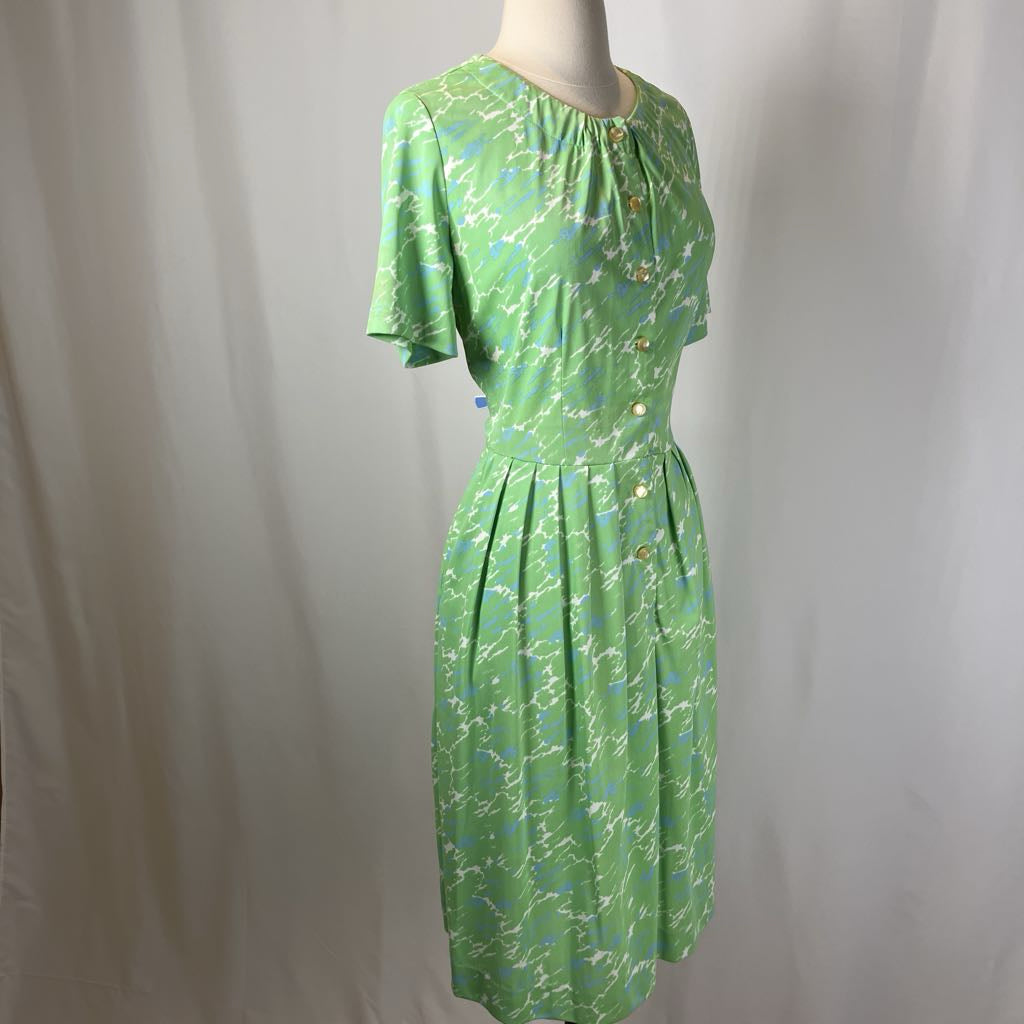 Green patterned dress on a mannequin against a plain background