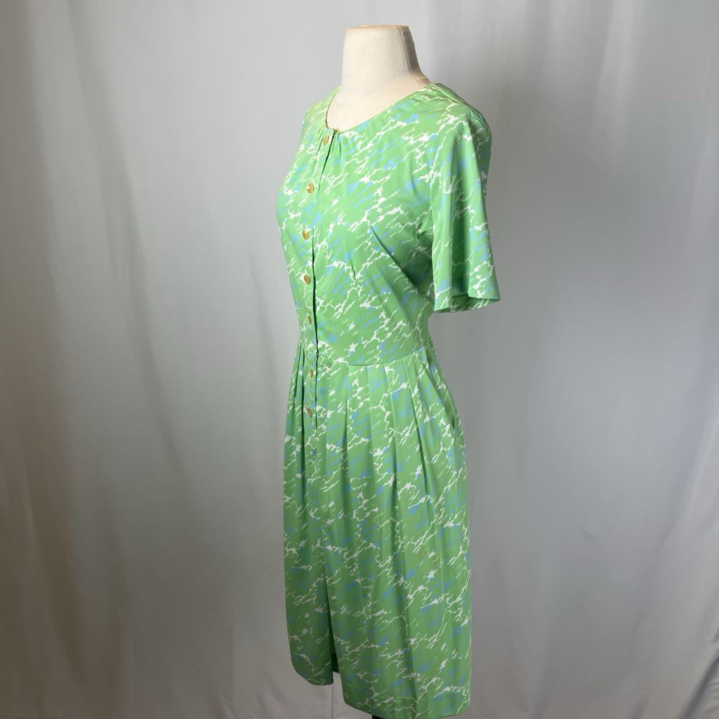 Green patterned dress on a mannequin against a plain background