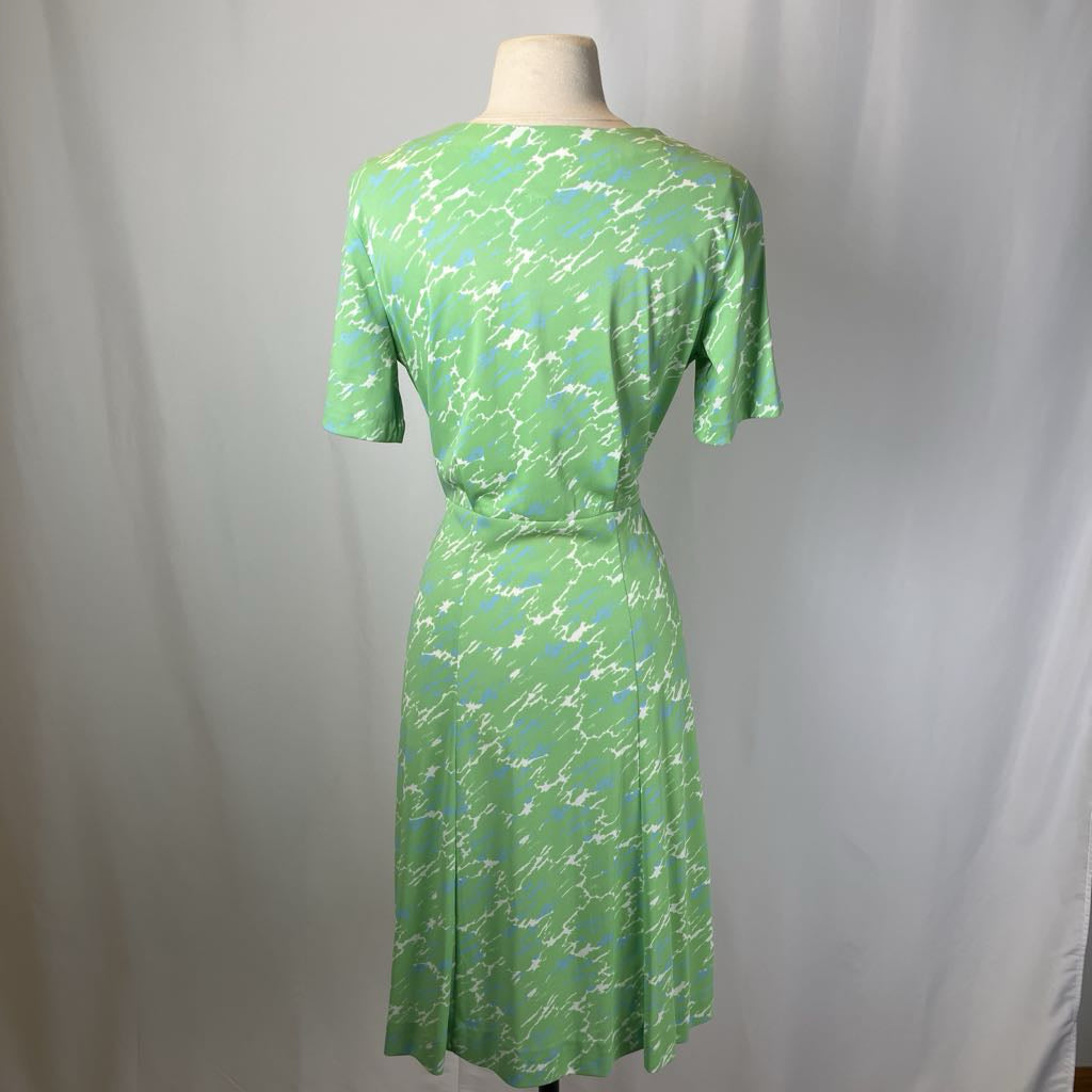Green patterned dress on a mannequin against a plain background