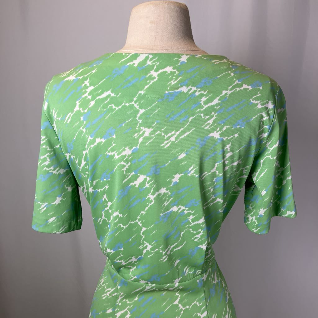 Green dress with abstract pattern on a mannequin against a gray background