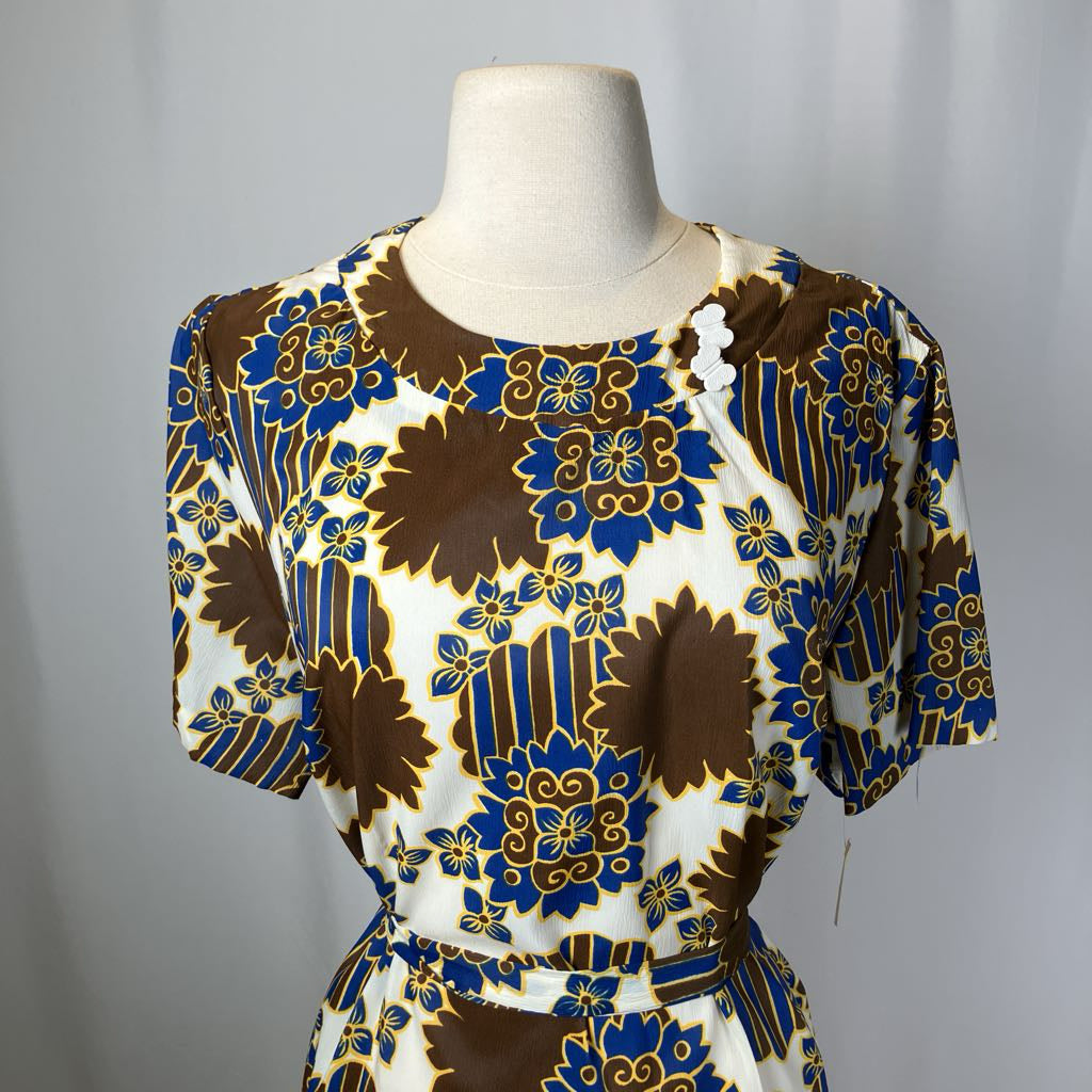 Mannequin wearing a dress with a brown, blue, and white floral pattern on a gray background