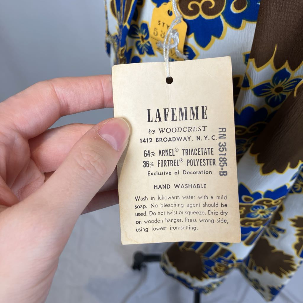 Clothing tag with 'Lafemme by Woodcrest' details held over a patterned fabric background.