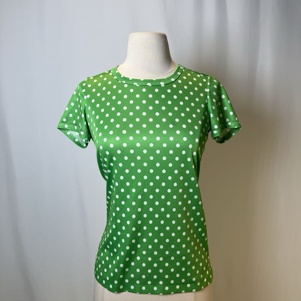 Green t-shirt with white polka dots on a mannequin against a plain background