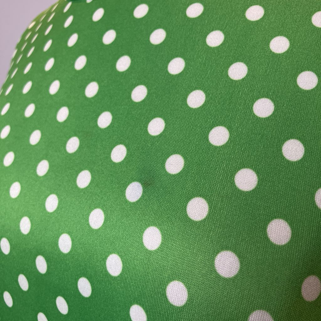 Green fabric with white polka dots