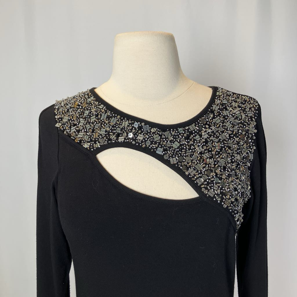 Black top with beading and a cutout on the chest against a white background.