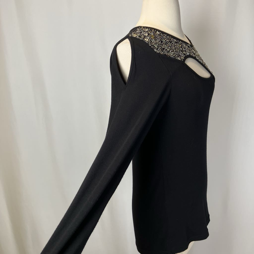 Black long-sleeve top with embellished neckline on a mannequin against a white background