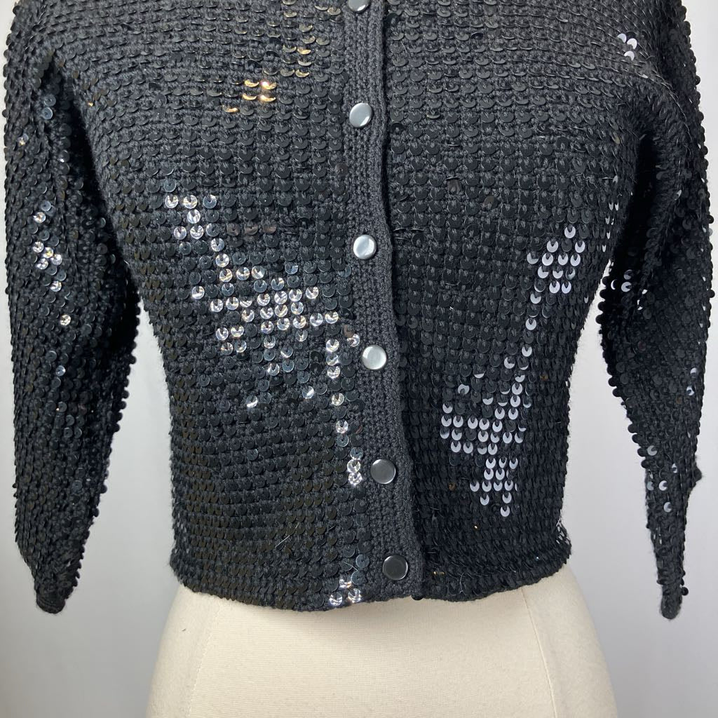 Black textured cardigan with sequin details on a mannequin against a white background