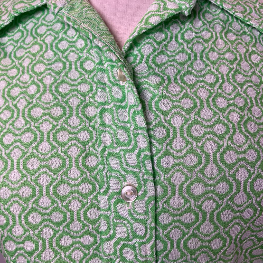 Close-up of a green and white patterned shirt with a button.