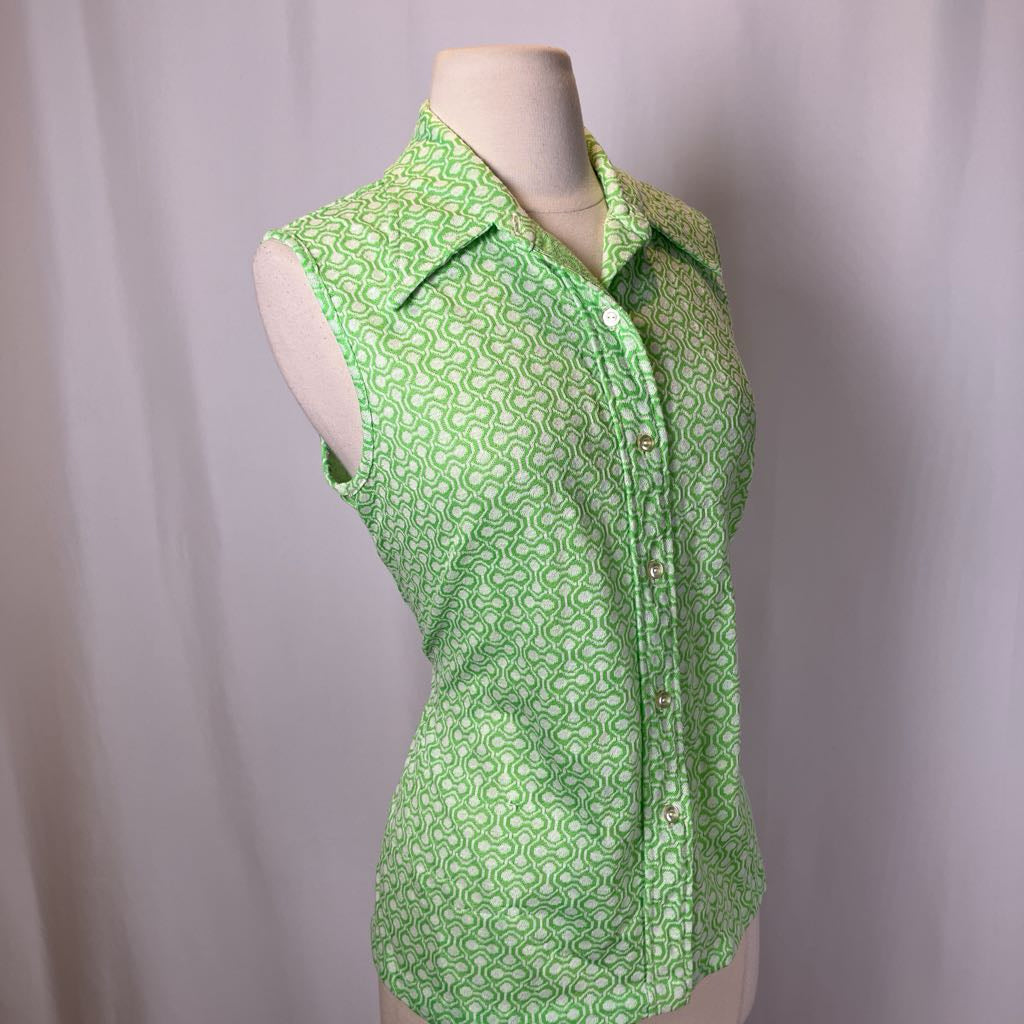 Green patterned sleeveless blouse on a mannequin against a plain background