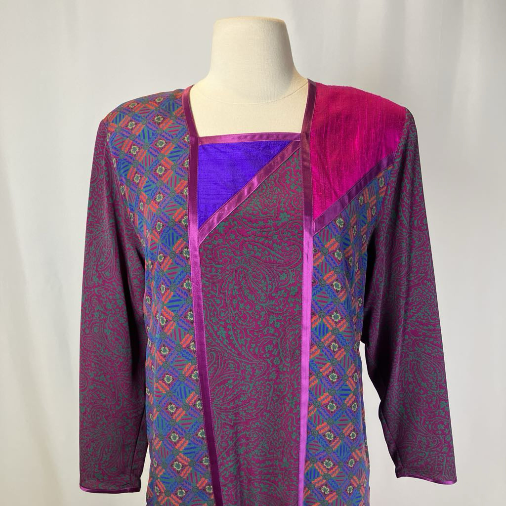 Mannequin wearing a colorful patterned top with a plain background