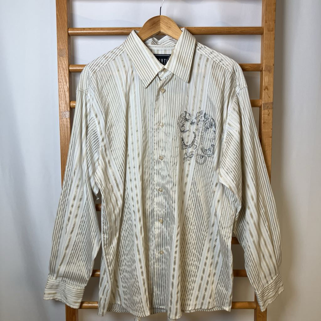 Striped shirt with a logo on a wooden rack against a white wall