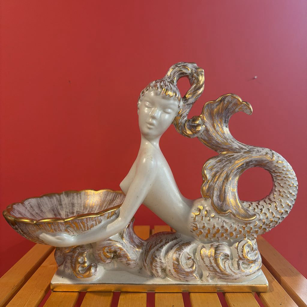 Decorative figurine of a woman with a peacock on a red background
