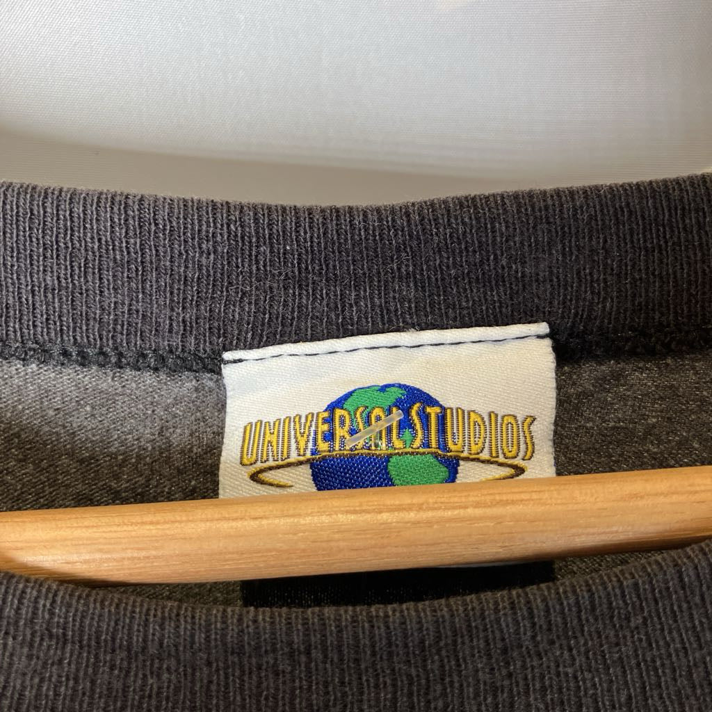 Gray sweatshirt with a Universal Studios tag on a wooden hanger.